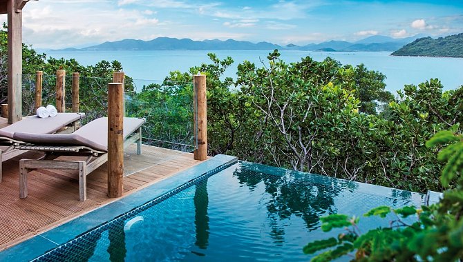 Privater Pool mit Liegen und Blick auf das Meer und umliegende Inseln.