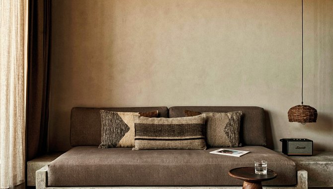 Der Sitzecke im Wohnzimmer steht das Sofa gegenüber. Es ist an der Wand mit dem Sideboard verbunden, welches als zusätzliche ablagefläche dient. rechts neben dem braunen Sofa steht eine Musikbox