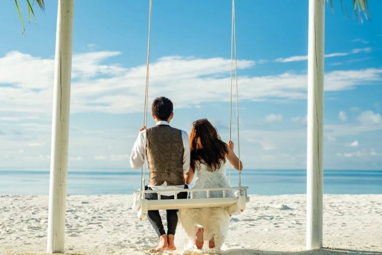 Ehepaar auf einer Schaukel am Strand