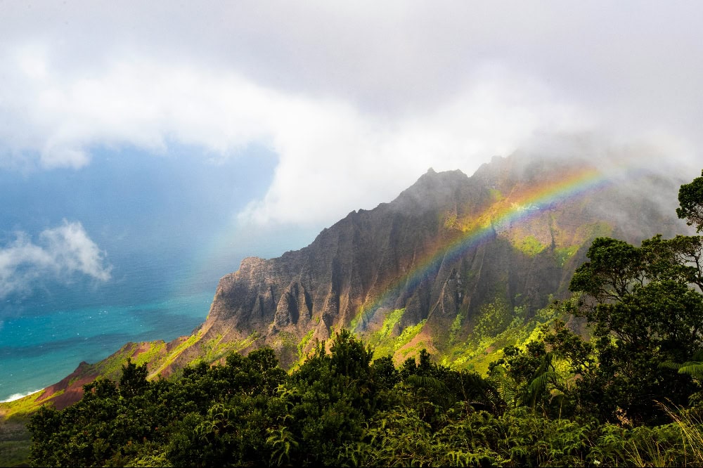 Regenbogen über den dramatischen Felsen und Küstenbergen der Insel Kauai.