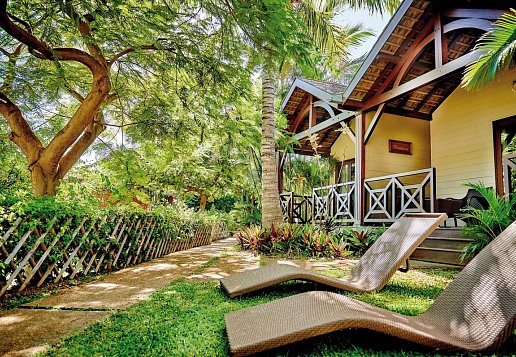 Sonnenliegen in der Gartenanlage vor den Bungalows