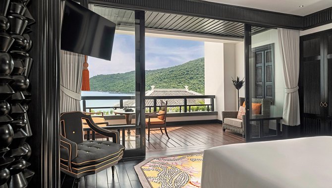 Helles Hotelzimmer mit Doppelbett und Balkon, Ausblick auf die Küste