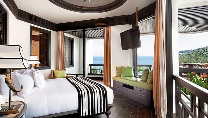 Hotelzimmer mit großem Bett, Meerblick und Sitzbank am Fenster