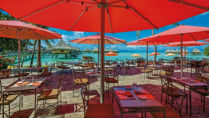 Restaurant mit roten Sonnenschirmen am Meer