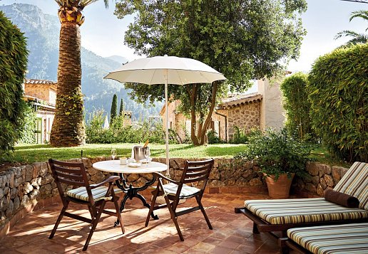 Garten mit Liegen und kleinem Tisch mit Stühlen