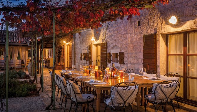 Gedeckter Esstisch unter Weinreben abends