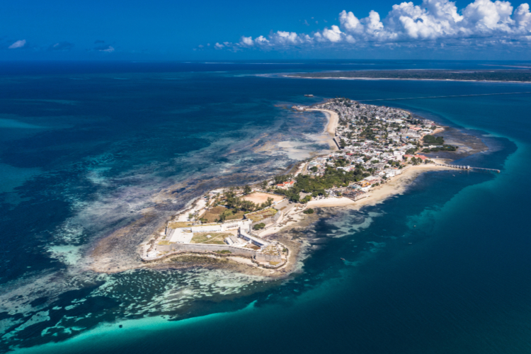 Luftaufnahme der Ilha de Moçambique mit historischen Gebäuden und türkisfarbenem Meer.