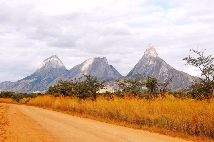Spektakuläre Granitfelsen und Inselberge in Mosambik mit goldgelbem Gras im Vordergrund.