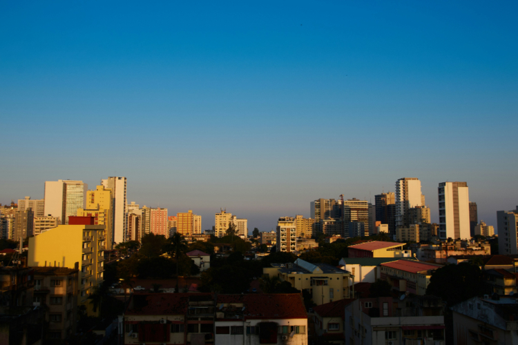 Skyline von Maputo mit modernen Hochhäusern und Wohngebieten bei klarem Abendhimmel.