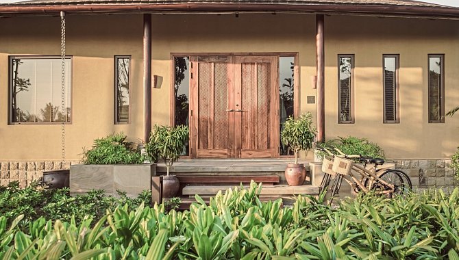 Traditionelles Eingangstor der Villa mit Pflanzen und Fahrrad