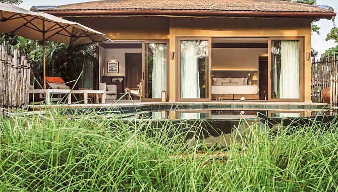 Villa mit Terrasse, Sonnenschirm und Pool, Blick ins Schlafzimmer