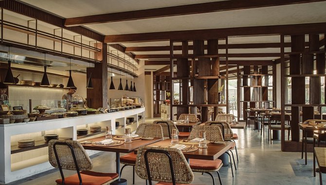 Modernes Restaurant mit offener Küche, Holzelementen und gedeckten Tischen