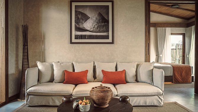 Heller Wohnraum mit Sofa, Kissen und dekorativem Wandbild