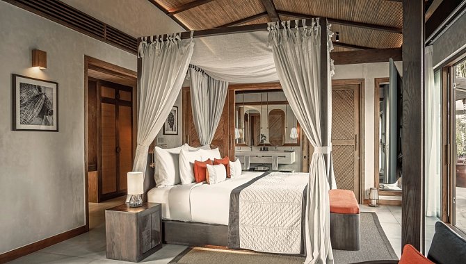 Luxuriöses Zimmer mit Himmelbett, warmen Holzelementen und Sitzbank