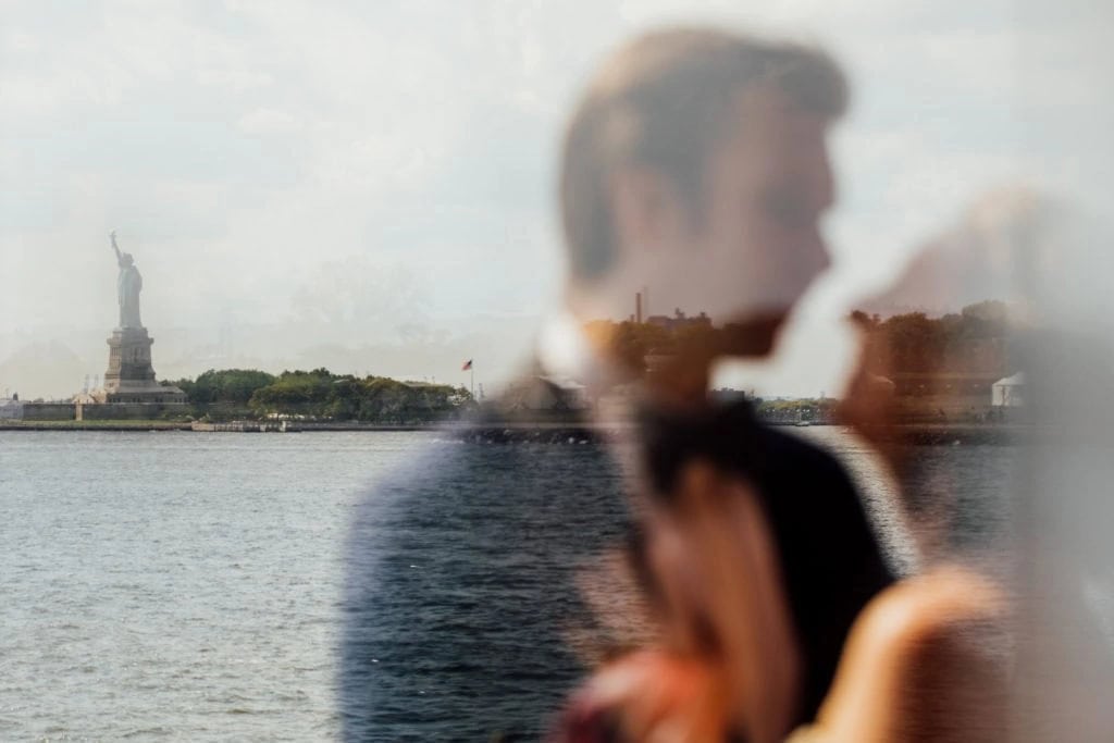 Eine verschwommene Spiegelung eines Hochzeitspaares vor der Freiheitsstatue