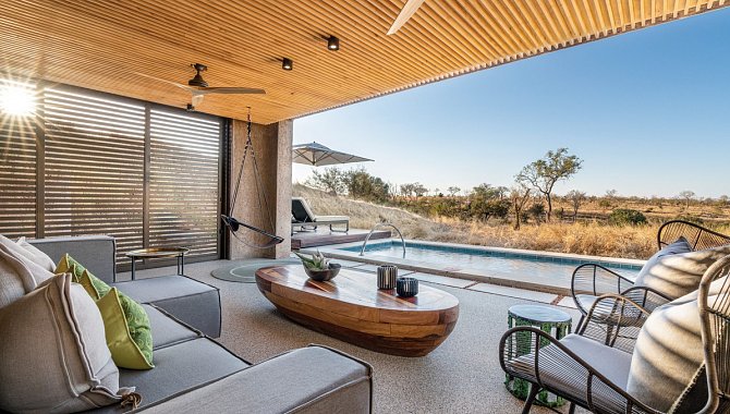 Hotelzimmer mit großer Fensterfront in die Landschaft