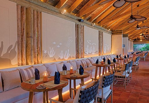 Hotelrestaurant direkt am Strand, lange Sofa wand mit zweiertischen