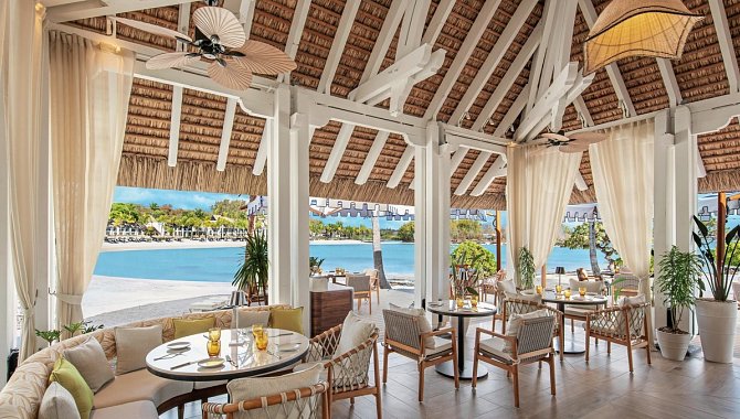 Strandnahes, offen gestaltetes Restaurant mit luftiger Holzdecke und Blick auf die Lagune