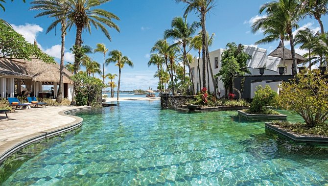 Großer Lagunenpool mit Palmen und harmonischem Übergang zur Lagune