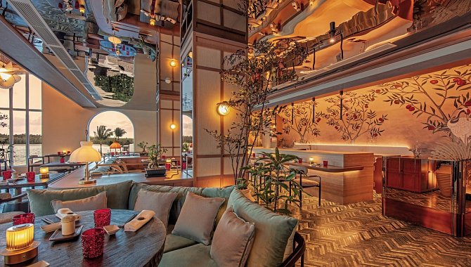 Gourmetrestaurant mit gedämpfter Beleuchtung, Pflanzen und Meerblick