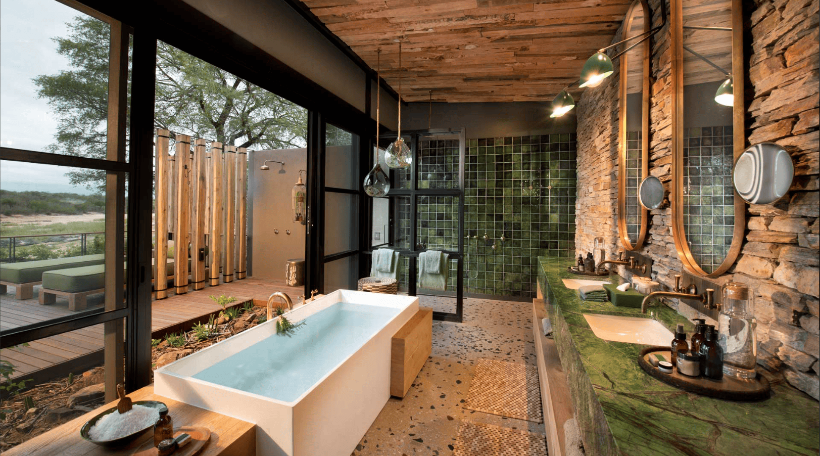 Luxuriöses Badezimmer mit freistehender Badewanne, Naturstein und Außendusche