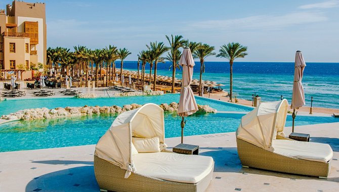 Poolanlage des Hotels mit meerblick. Große gepolsterte Liegen für 2 Personen mit Sonnenschutz