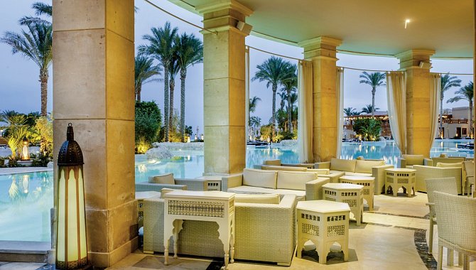 Offener überdachter Sitzbereich direkt neben der Poolanlage.