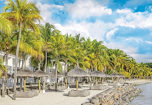 Strand mit Sitzmöglichkeiten, Sonnenschirmen und Palmen