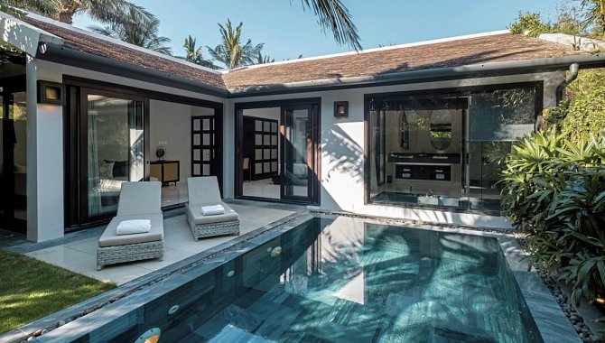 Privater Innenhof mit Pool, Liegen und umrahmt von tropischen Pflanzen.