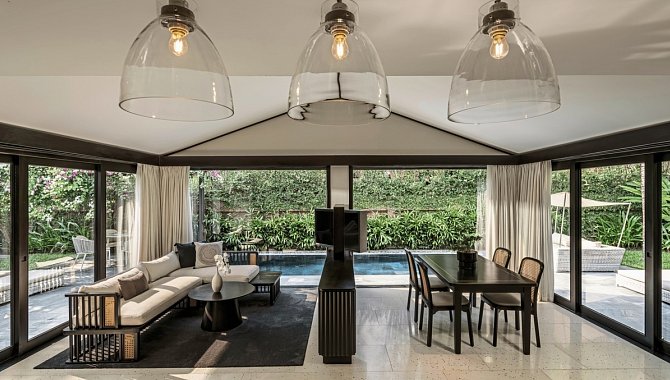 Moderner Wohn- und Essbereich mit Glasfront und Blick auf privaten Pool