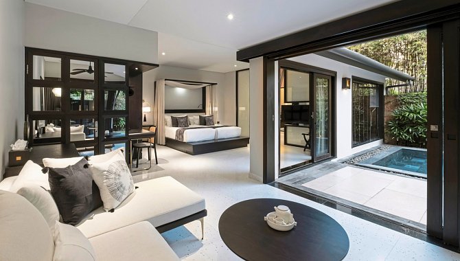 Offene Suite mit Sofa, Bett und Zugang zum privaten Pool.