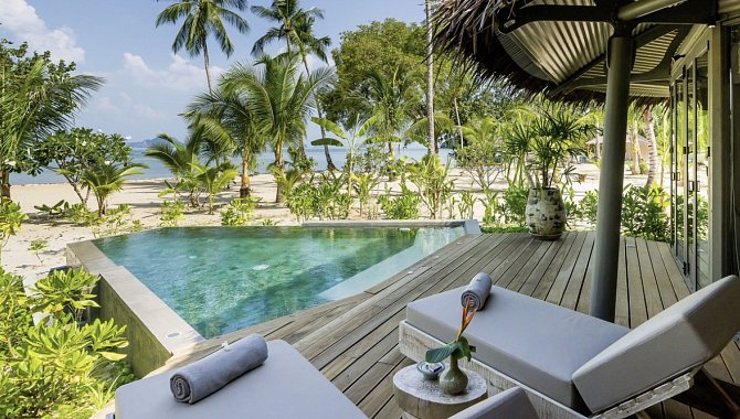 Pool mit Palmen und Liegen