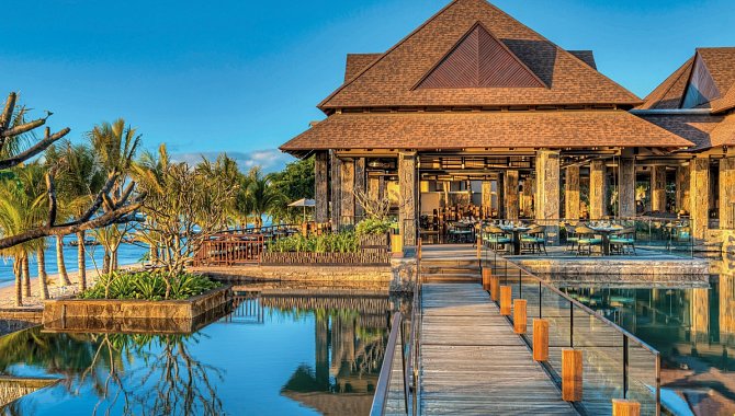Holzsteg über dem Wasser, umgeben von stilvollen Outdoor-Restaurants und tropischer Gartenanlage im Westin Turtle Bay Resort & Spa.